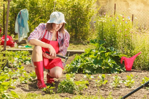 Gardener carrying out safe garden maintenance with protective equipment